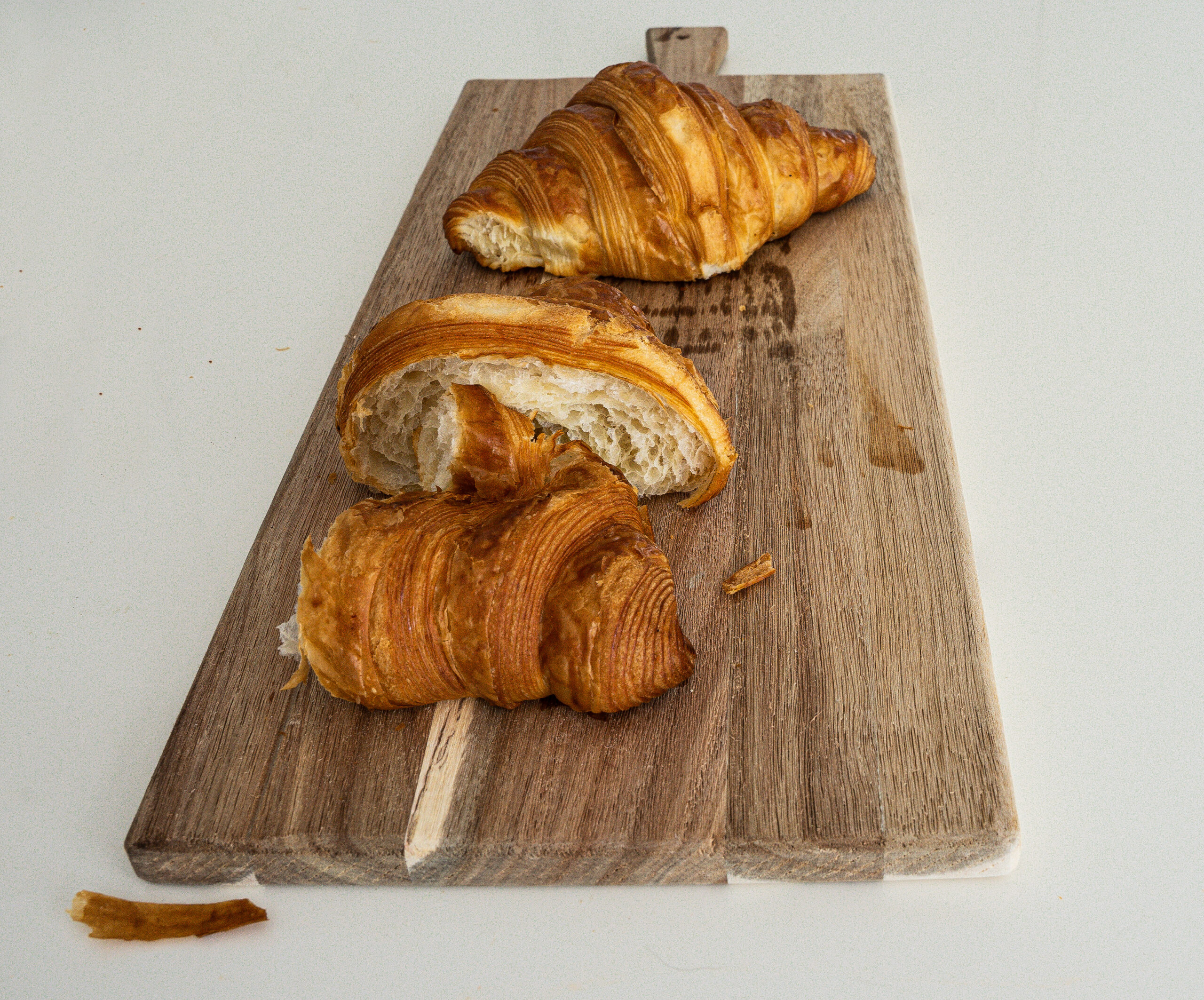 Fresh buttery croissant on a plate at Odeon café in Dubai, capturing a slow Sunday morning moment.